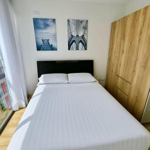 a bed in a bedroom with two pictures on the wall at Exclusive Tiny Loft in Usaquén in Bogotá