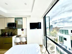 a bedroom with a large window with a view at Exclusive Tiny Loft in Usaquén in Bogotá
