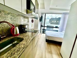 a kitchen with a sink and a bed in a room at Exclusive Tiny Loft in Usaquén in Bogotá