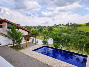 a villa with a swimming pool and a resort at Casaazulvaleparaiba in Jacareí