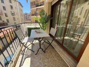 a balcony with a table and chairs on a balcony at Appartement Spacieux au Port de Nice avec Clim et Parking Gratuit in Nice