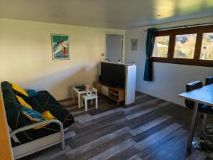 a living room with a couch and a flat screen tv at à la claire fontaine in Vizille