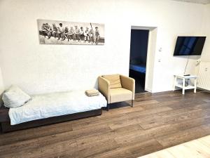 a room with a bed and a chair and a television at Monteur Oase Leipzig Nord in Schkeuditz