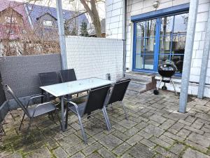 a table and chairs on a patio with a grill at Monteur Oase Leipzig Nord in Schkeuditz