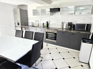 a kitchen with a table and chairs and appliances at Monteur Oase Leipzig Nord in Schkeuditz