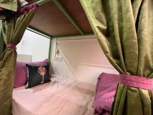 a bed in a room with a curtain at ReneeMysa in Indore
