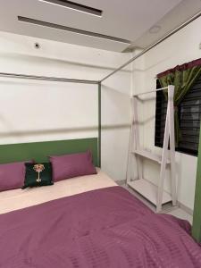 a bedroom with a bed with purple and green at ReneeMysa in Indore