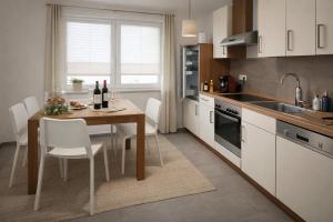a kitchen with a wooden table and white cabinets at Giovanna Ferienwohnung in Müllenbach