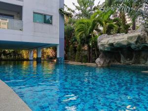 a swimming pool in front of a building at คลับรอยัล2bed in North Pattaya