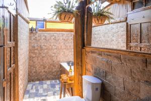 a bathroom with a toilet in a brick wall at Hotel - Posada Las Rocas - Guasca Cundinamarca in El Lindero