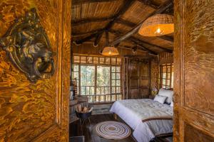 a bedroom with a bed in a room with wooden walls at Hotel - Posada Las Rocas - Guasca Cundinamarca in El Lindero
