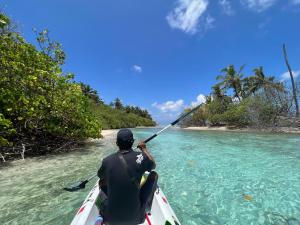 a man in a kayak in the water at Vaadhee Homestay in Guraidhoo