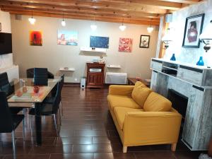 a living room with a yellow couch and a fireplace at Panaghie in Hangul
