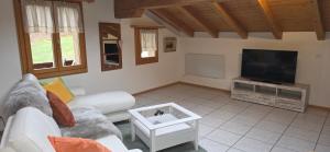 a living room with a couch and a flat screen tv at Wohnung in Reichenbach im Kandertal in Reichenbach