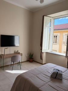 a bedroom with a bed and a desk and a window at The Reggia Nest in Caserta