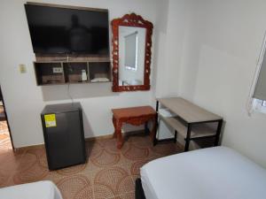 a bedroom with a bed and a mirror and a desk at Hotel Cascada in Ríohacha