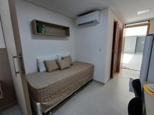 a small bedroom with a bed with pillows on it at Departamento ideal in Ipojuca