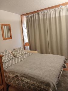 a bedroom with a bed and a window with curtains at Studio Isola 2000 in Isola 2000