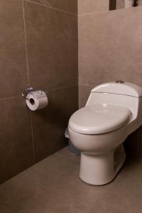 a bathroom with a toilet and a roll of toilet paper at The Living Hub in La Dorada