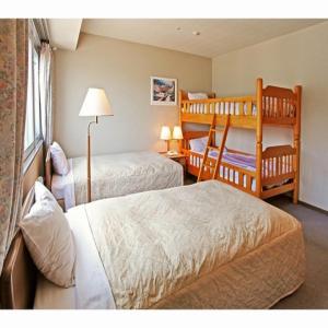 a hotel room with two beds and a bunk bed at Hotel Crown Hills Takefu in Echizen-shi