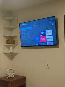 a flat screen tv hanging on a wall at Apartamento com sala e cozinha no morro da saudade in Morro de São Paulo