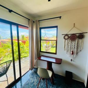 a desk and a chair in a room with a window at Kitesurf Oasis Maracajaú in Maracajaú