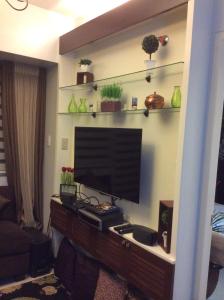 a living room with a flat screen tv on a wall at Condo at Parkside Villas across the airport in Manila +2 photos