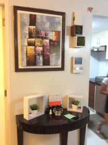 a table in a room with a painting on the wall at Condo at Parkside Villas across the airport in Manila