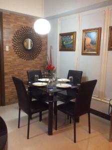 a dining room with a black table and chairs at Condo at Parkside Villas across the airport in Manila