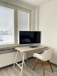 a desk with a chair and a television in a room at Centerpoint Imatra in Imatra