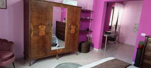 a purple room with a wooden cabinet with a mirror at Casa Rosa in Sogliano Cavour +83 photos