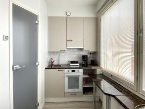 a kitchen with white cabinets and a stove top oven at Centerpoint Imatra in Imatra +5 photos