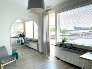 a living room with a large window and a kitchen at Centerpoint Imatra in Imatra