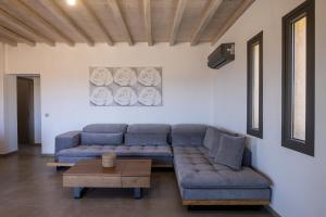 a living room with a couch and a table at Marilias cycladic home in Agios Fokas