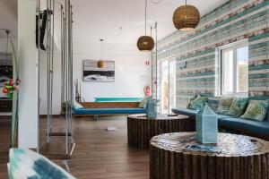 a living room with two blue couches and two tables at Sagres Natura in Sagres