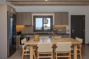 a kitchen with a wooden table and chairs in it at Marilias cycladic home in Agios Fokas