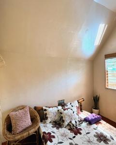 a bedroom with a bed and a wicker chair at Cabin Camping at Balay Hilway in Sara