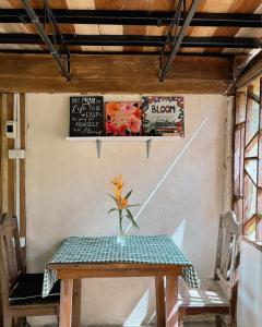 a wooden table with a vase of flowers on it at Cabin Camping at Balay Hilway in Sara