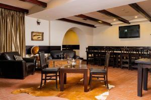 a room with a bar with chairs and a table at Pension Casa Vanatorilor in Băile Olăneşti