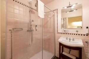 a bathroom with a glass shower and a sink at Hotel Patria in Pistoia +44 photos