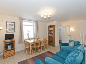 a living room with a blue couch and a table at Tinakori in Staithes