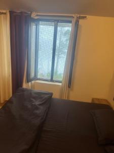 a bedroom with a bed and a large window at Peaceful Pines Cottage in Bhowāli +1 photo