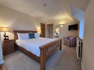 a bedroom with a large bed and a chair at The Ullapool Rooms in Ullapool