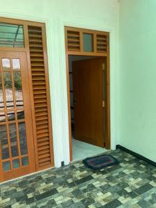 an empty room with doors and a room with a mat at Chandani Hostel in Galle