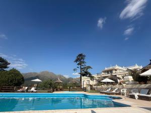 Ein Pool in einem Resort mit Bergen im Hintergrund in der Unterkunft Montecassino in Capilla del Monte