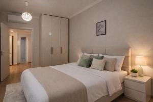 a bedroom with a large white bed with pillows at Red School Central Apartment New Bazaar in Tirana
