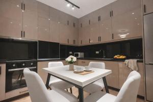 a kitchen with a white table and white chairs at Red School Central Apartment New Bazaar in Tirana