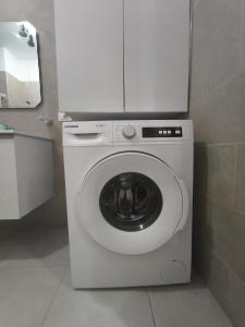 a washing machine with a white cabinet on top of it at Red School Central Apartment New Bazaar in Tirana