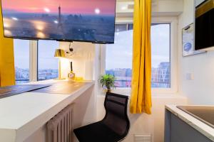 a kitchen with a black chair at a counter with a window at Paris - Blue Sky Homestay in Le Kremlin-Bicêtre