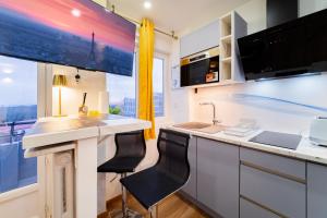 a kitchen with a sink and a counter with two chairs at Paris - Blue Sky Homestay in Le Kremlin-Bicêtre